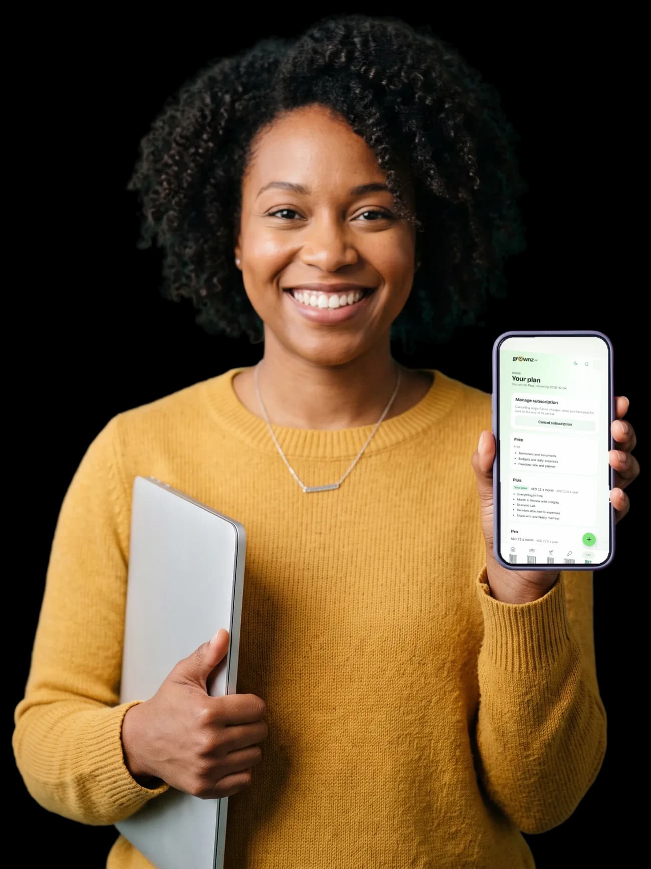 A woman with a laptop under her arm holding her phone up to the camera, the Your plan screen showing