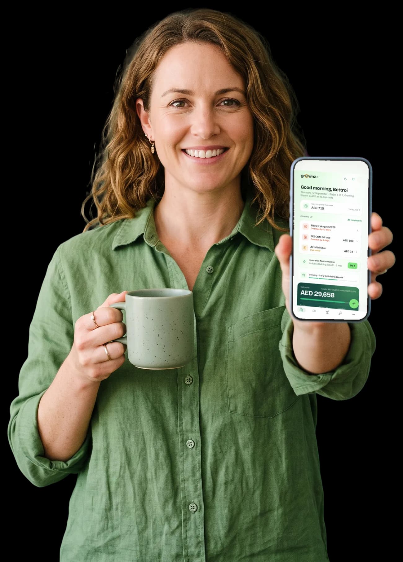 A woman with a sage mug holding her phone up to the camera, the Grownz home screen showing