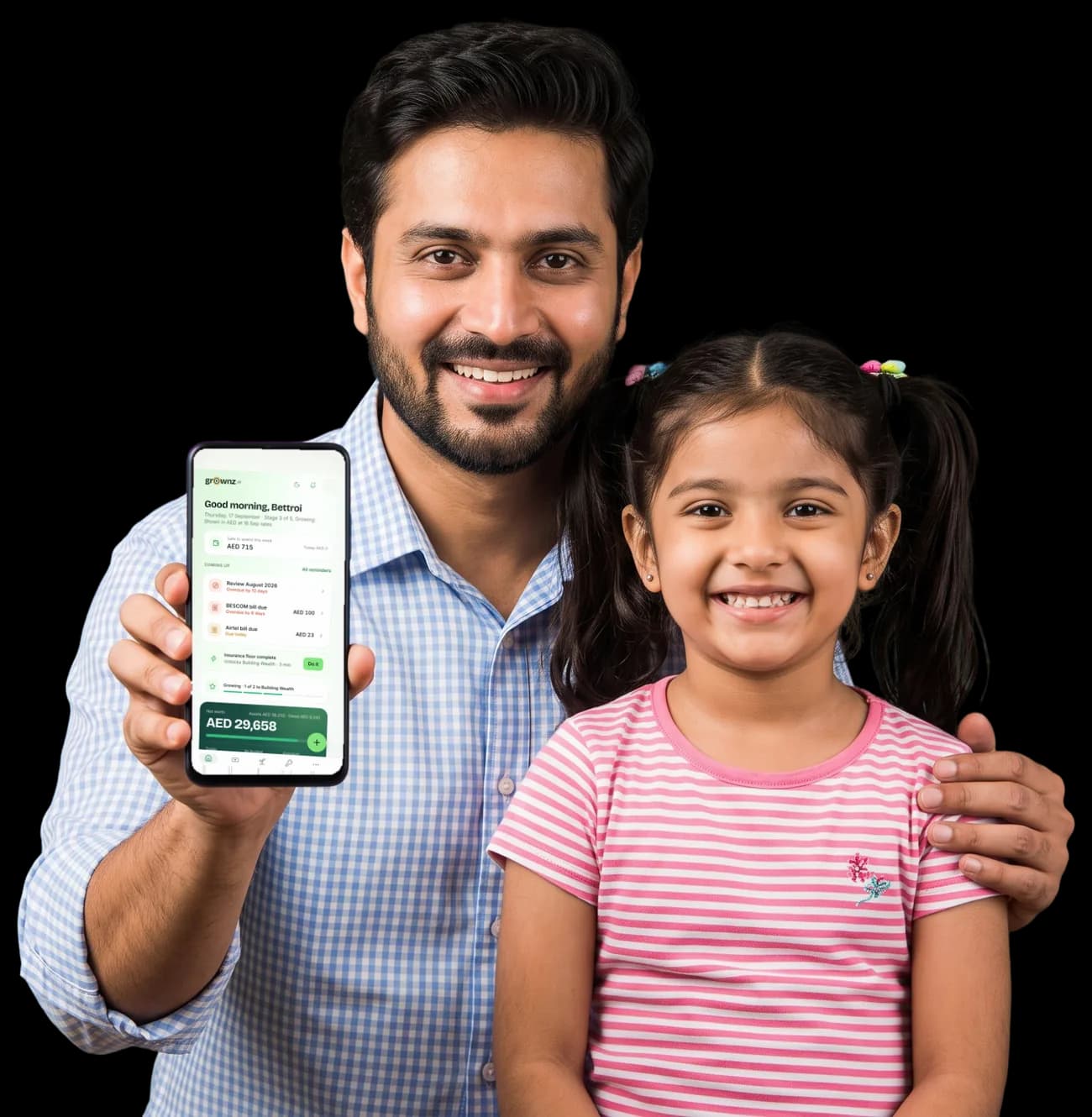 A father and his young daughter, the father holding a phone up to the camera with the Grownz home screen showing