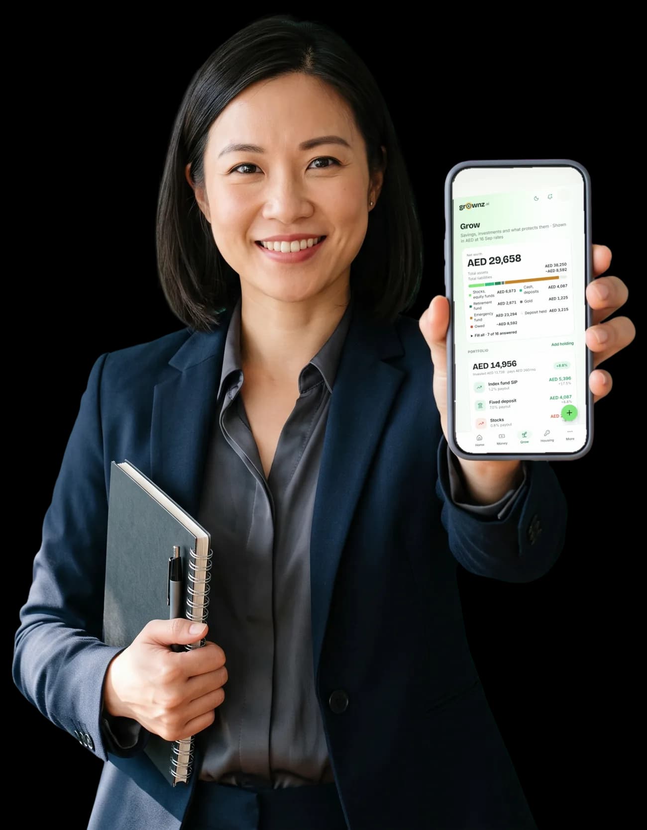 A woman in office wear with a notebook holding her phone up to the camera, the Grow screen showing